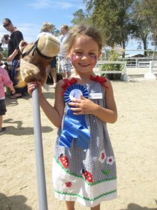 Ava Lanigan was just tickled to win her first place blue ribbon in the stick horse race!